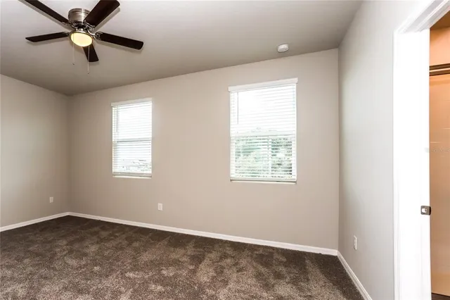 an empty room with a window and a fan