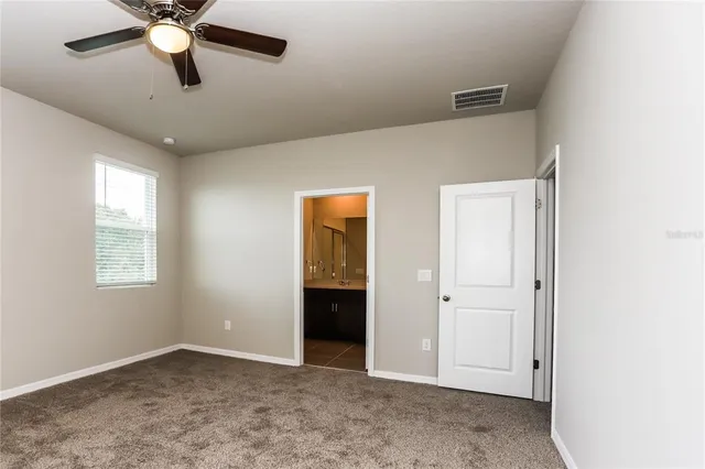 an empty room with closet and windows