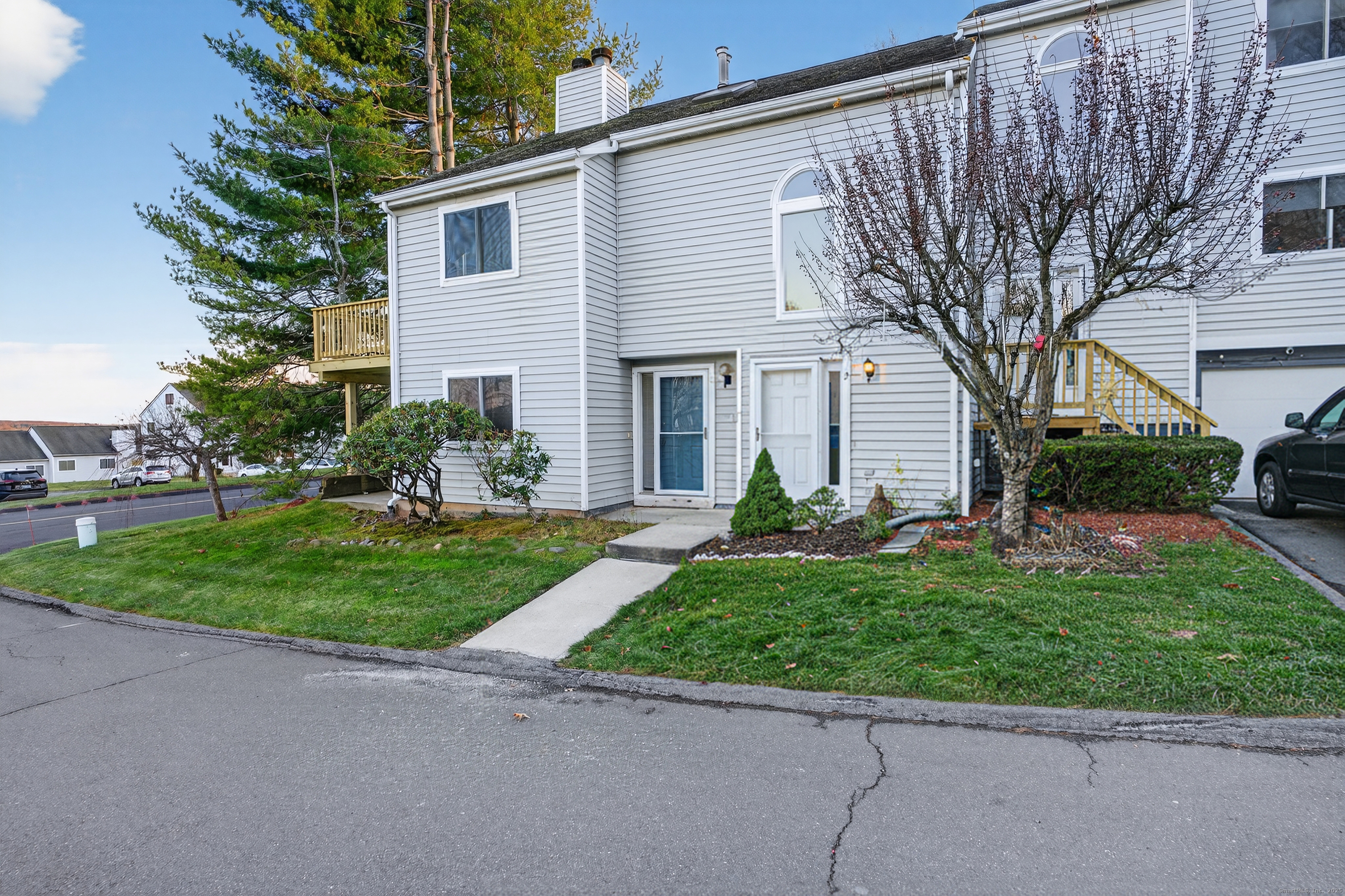 a front view of a house with a yard and potted plants