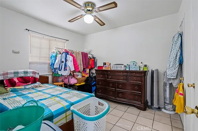 a bedroom with furniture and a chandelier fan