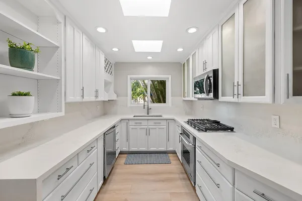 a kitchen with white cabinets and white appliances