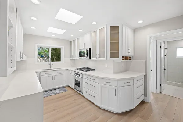 a kitchen with stainless steel appliances a stove a microwave and a sink