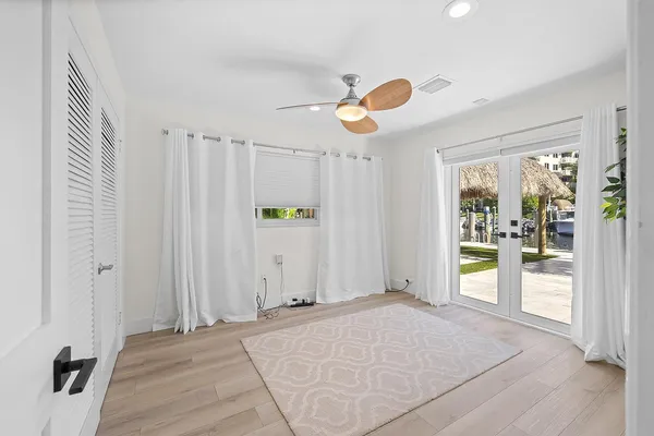 a view of a livingroom with a chandelier fan and windows