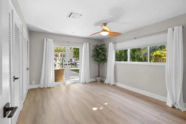 an empty room with wooden floor and windows