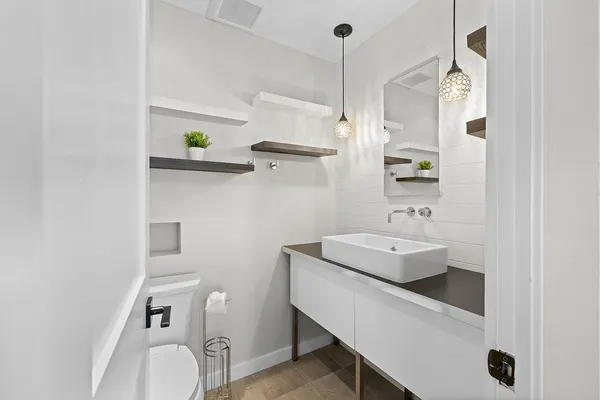 a bathroom with a sink a toilet and shower