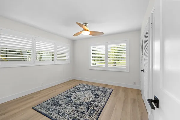 a view of a room with a hanging light and wooden floor