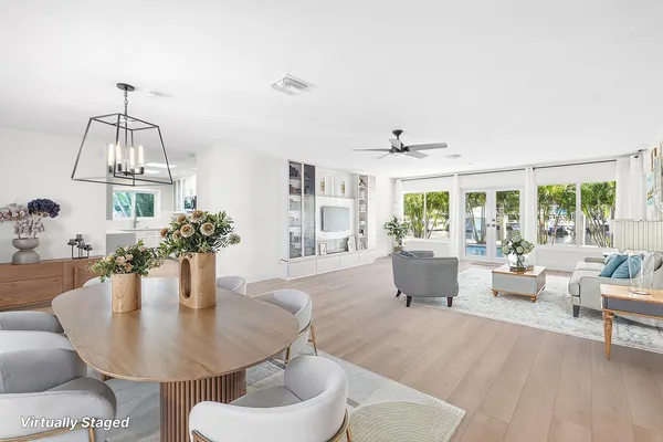 a living room with furniture a chandelier and a dining table