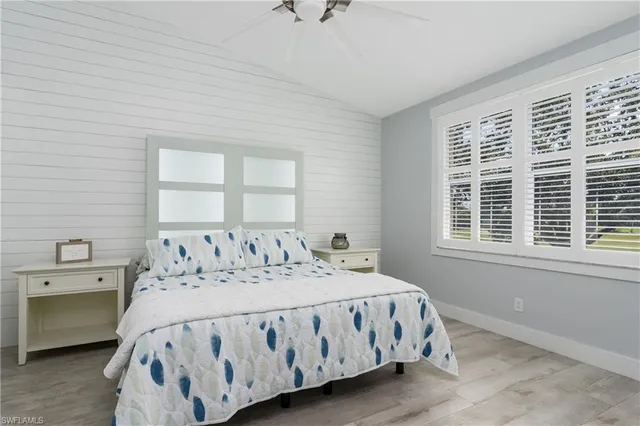 a bedroom with a bed next to a window with a dresser