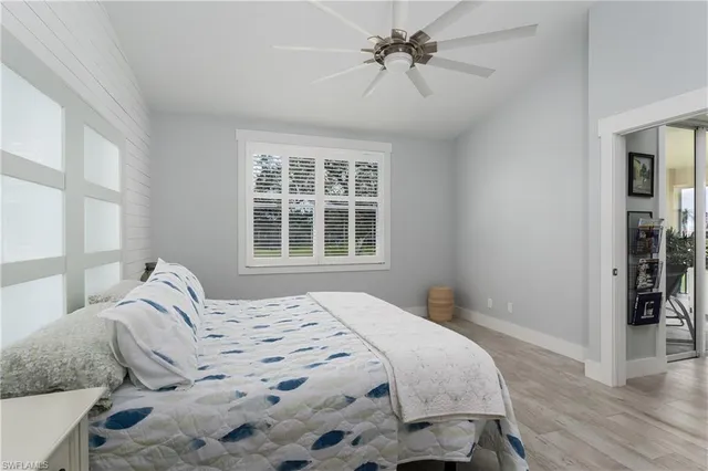 a bedroom with a large bed and wooden floor