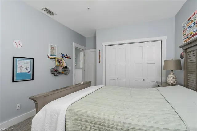 a bedroom with a large bed and painting on the wall