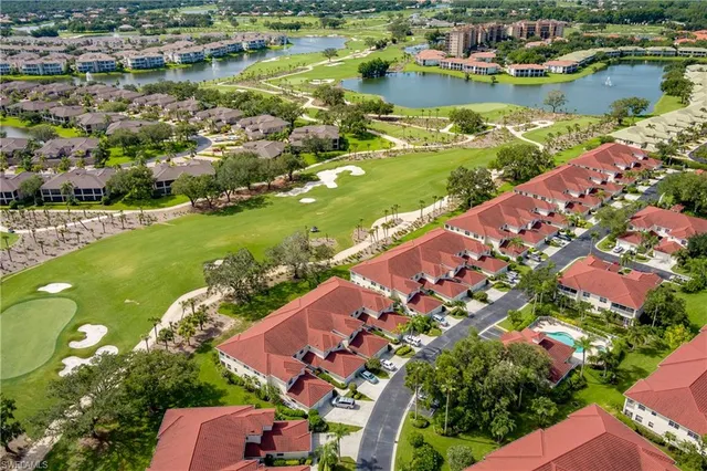 an aerial view of residential houses with outdoor space and lake view