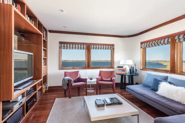 a living room with furniture wooden floor and a flat screen tv