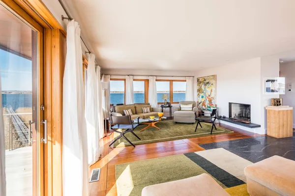 a living room with fireplace furniture and a large window
