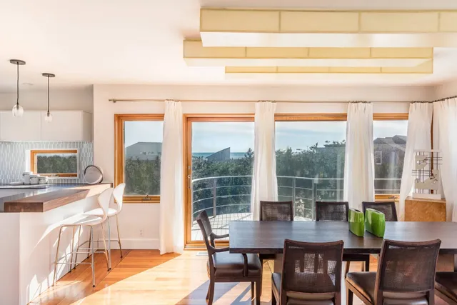a view of a dining room with furniture large windows and wooden floor