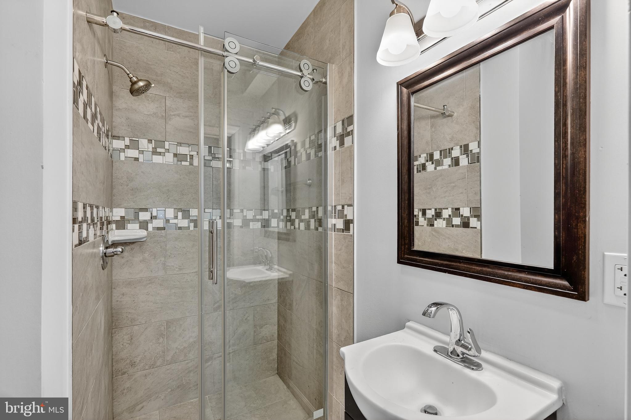 5619 1st Street Northwest, Unit 2 Washington, DC 20011 - Photo 16 of 27 a bathroom with a shower sink and mirror