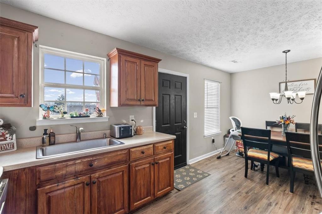 8 Stonegate Drive Cedartown, GA 30125 - Photo 12 of 42 a kitchen with stainless steel appliances granite countertop a sink dishwasher a stove a refrigerator with wooden cabinets and floor