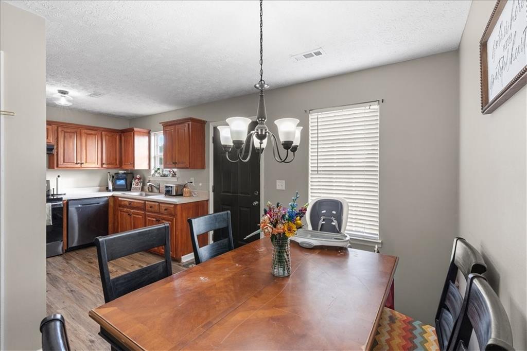 8 Stonegate Drive Cedartown, GA 30125 - Photo 15 of 42 a kitchen with stainless steel appliances granite countertop a refrigerator a sink dishwasher a dining table and chairs with wooden floor
