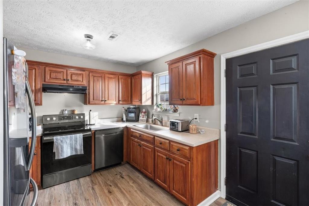 8 Stonegate Drive Cedartown, GA 30125 - Photo 9 of 42 a kitchen with stainless steel appliances granite countertop a sink stove cabinets and wooden floor