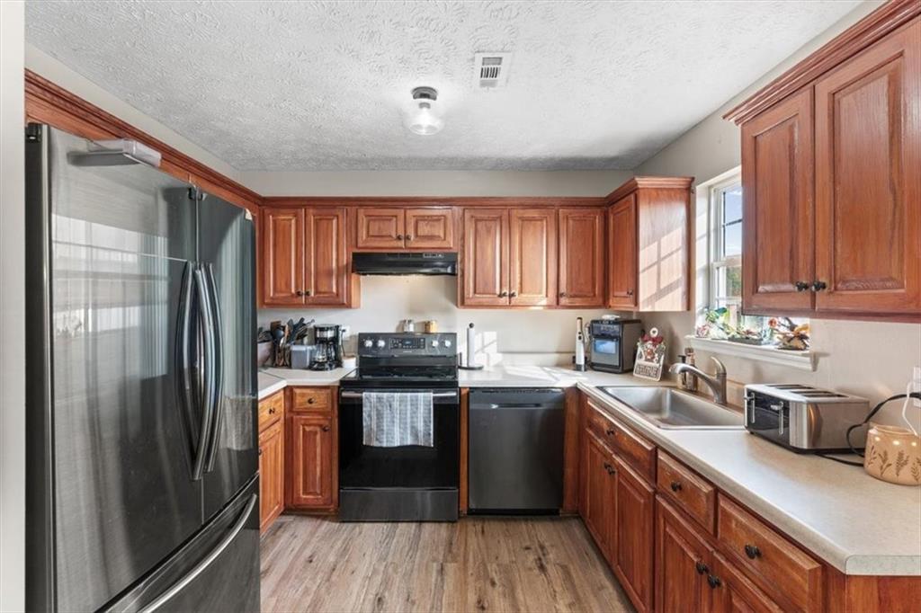 8 Stonegate Drive Cedartown, GA 30125 - Photo 10 of 42 a kitchen with stainless steel appliances granite countertop a stove top oven a sink dishwasher a refrigerator and cabinets with wooden floor
