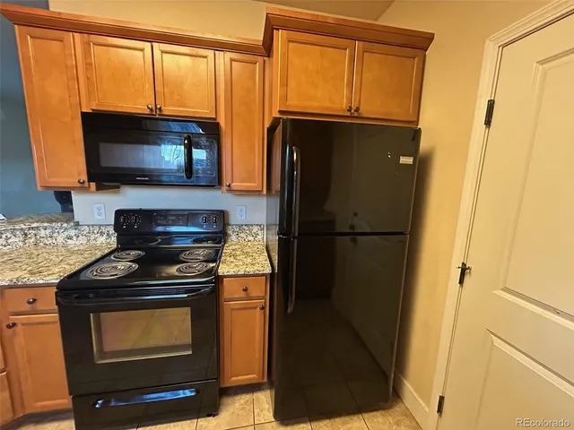 a kitchen with stainless steel appliances granite countertop a refrigerator stove and microwave