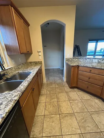 a kitchen with granite countertop a sink and a stove