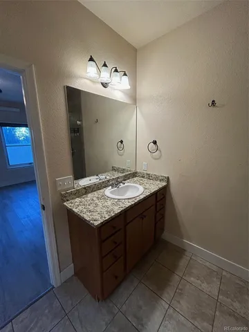 a bathroom with a granite countertop sink and a mirror