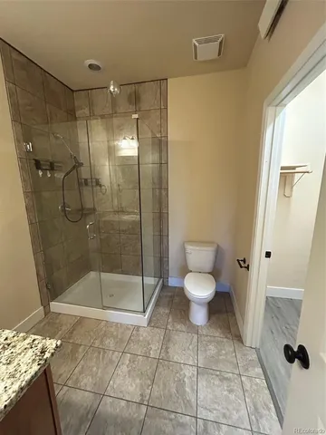 a bathroom with a toilet and a shower