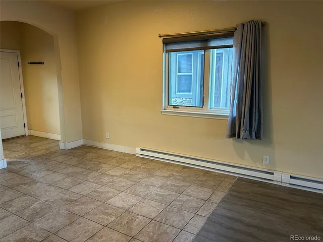 an empty room with wooden floor and a window