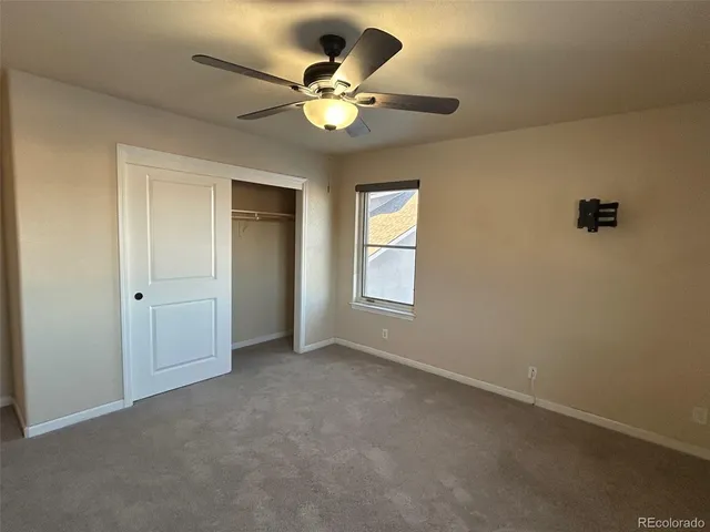 a view of an empty room with a chandelier fan