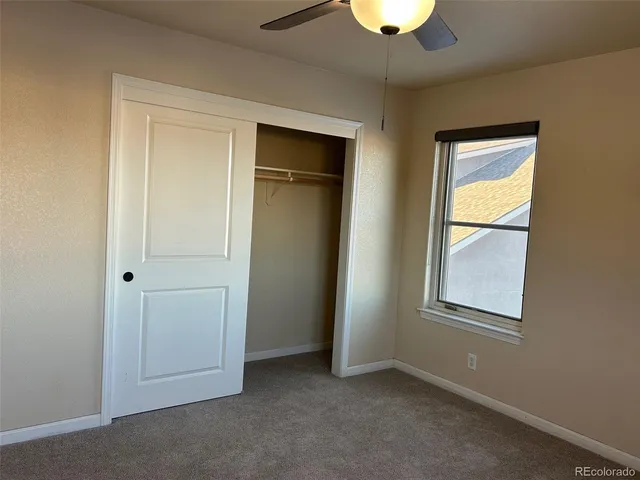 a bathroom with a granite countertop toilet sink and mirror