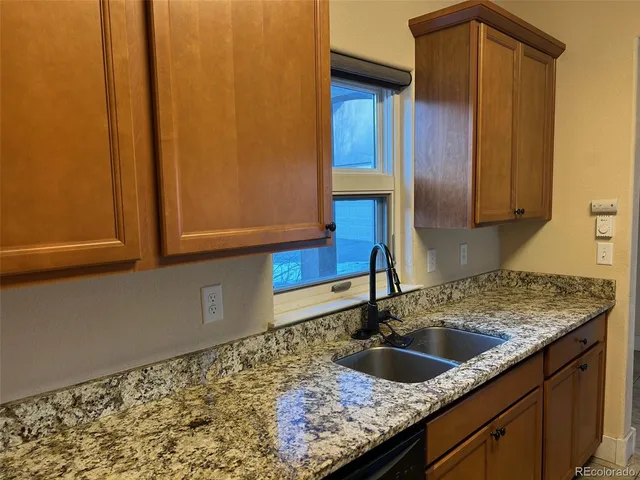 a kitchen with granite countertop sink and cabinets