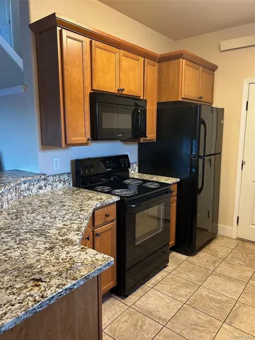 a kitchen with stainless steel appliances granite countertop a stove refrigerator and microwave