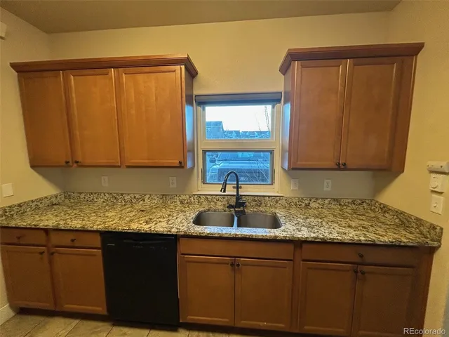 a kitchen with granite countertop a sink and cabinets