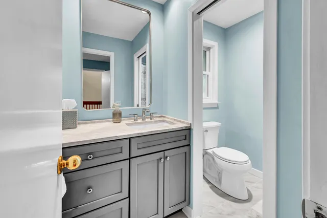 a bathroom with a granite countertop sink and a mirror