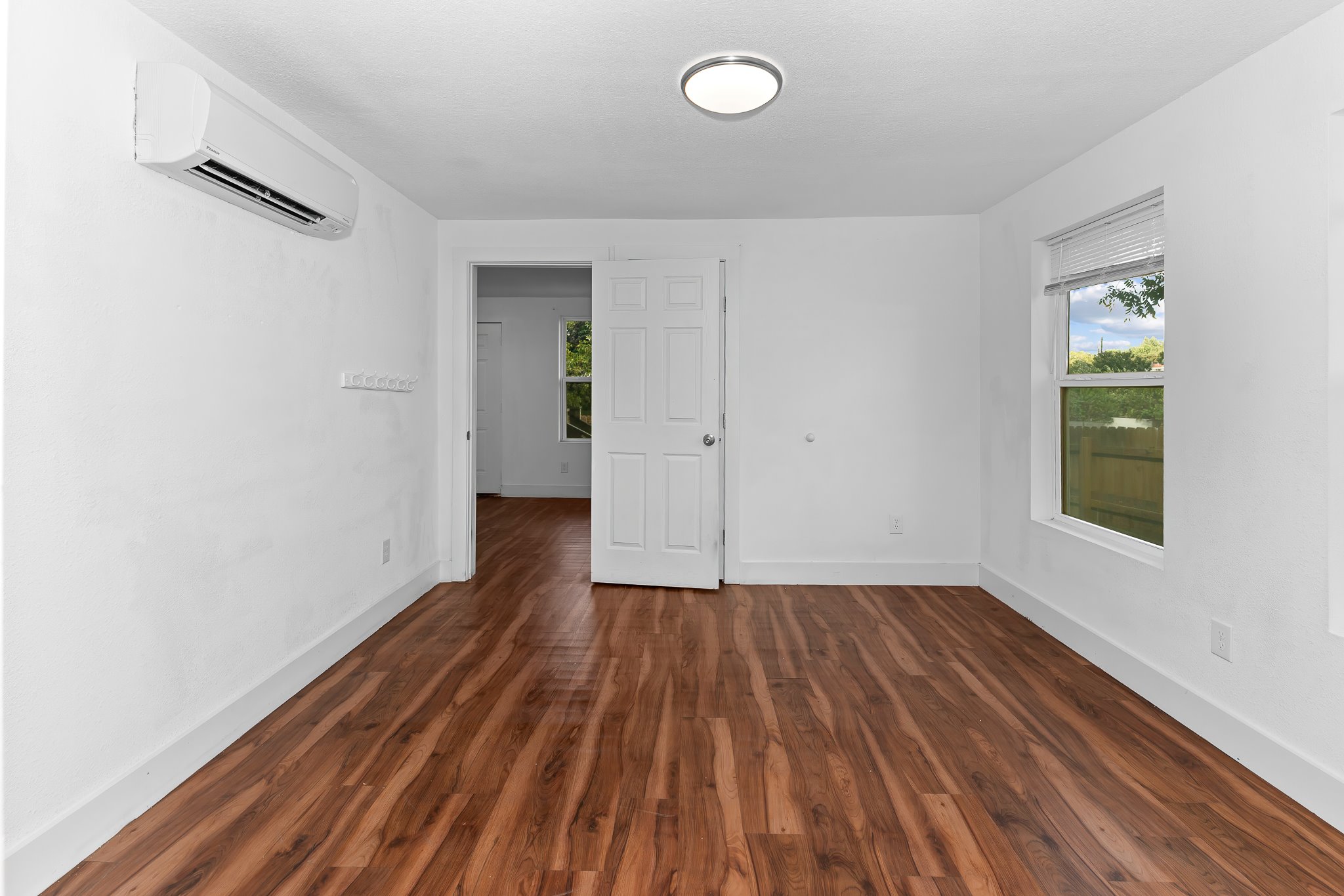 204 Lessin Lane Austin, TX 78704 - Photo 26 of 35 a view of an empty room with wooden floor and a window