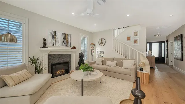 a view of a dining room with furniture a fireplace and wooden floor