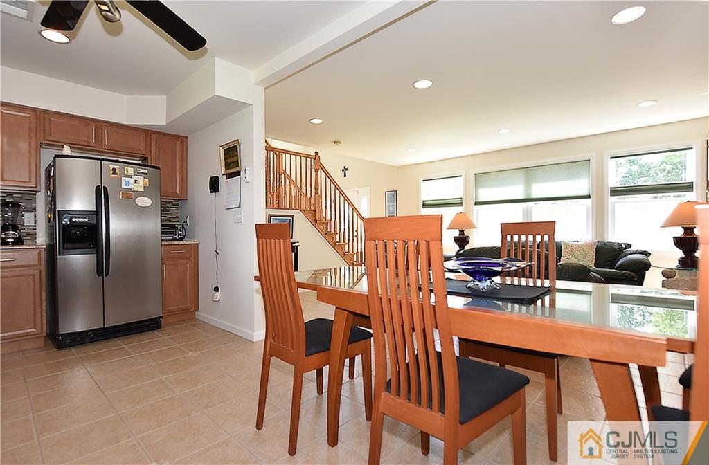 3 Caldwell Road Edison, NJ 08817 - Photo 12 of 25 a kitchen with stainless steel appliances granite countertop a refrigerator a stove a sink a dining table and chairs with wooden floor