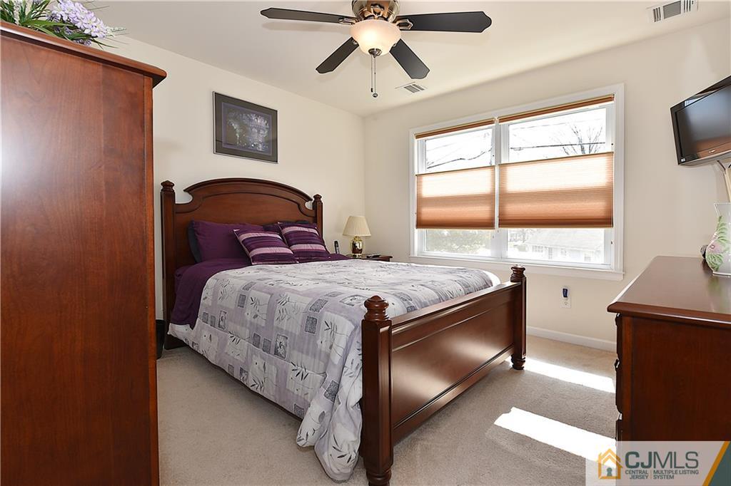 3 Caldwell Road Edison, NJ 08817 - Photo 22 of 25 a bedroom with a bed and a flat tv screen on the dresser