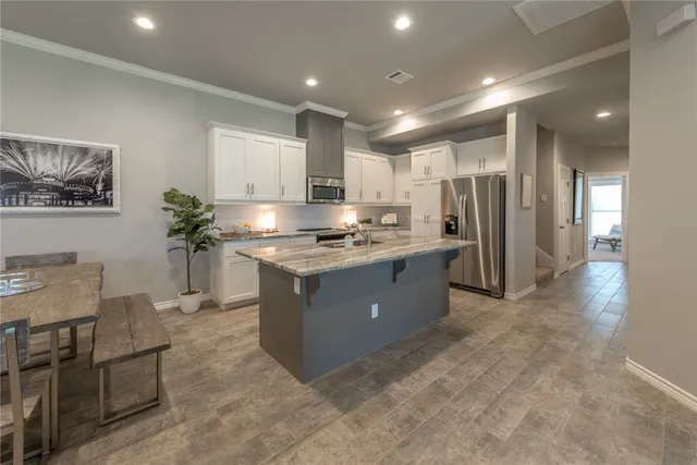 a bathroom with a granite countertop bathtub shower sink vanity and toilet