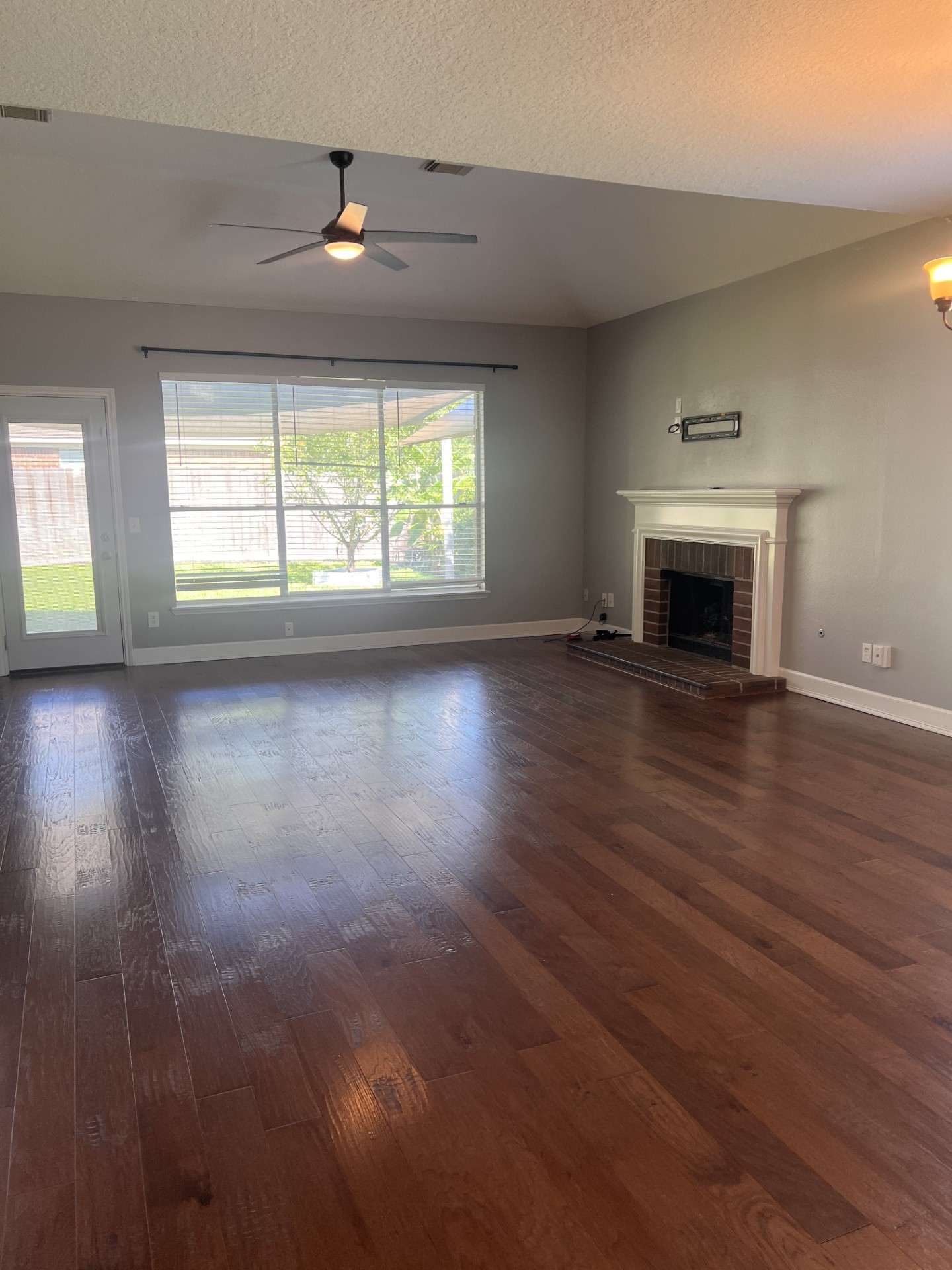 9327 Restover Lane Houston, TX 77064 - Photo 12 of 22 an empty room with wooden floor fireplace and windows
