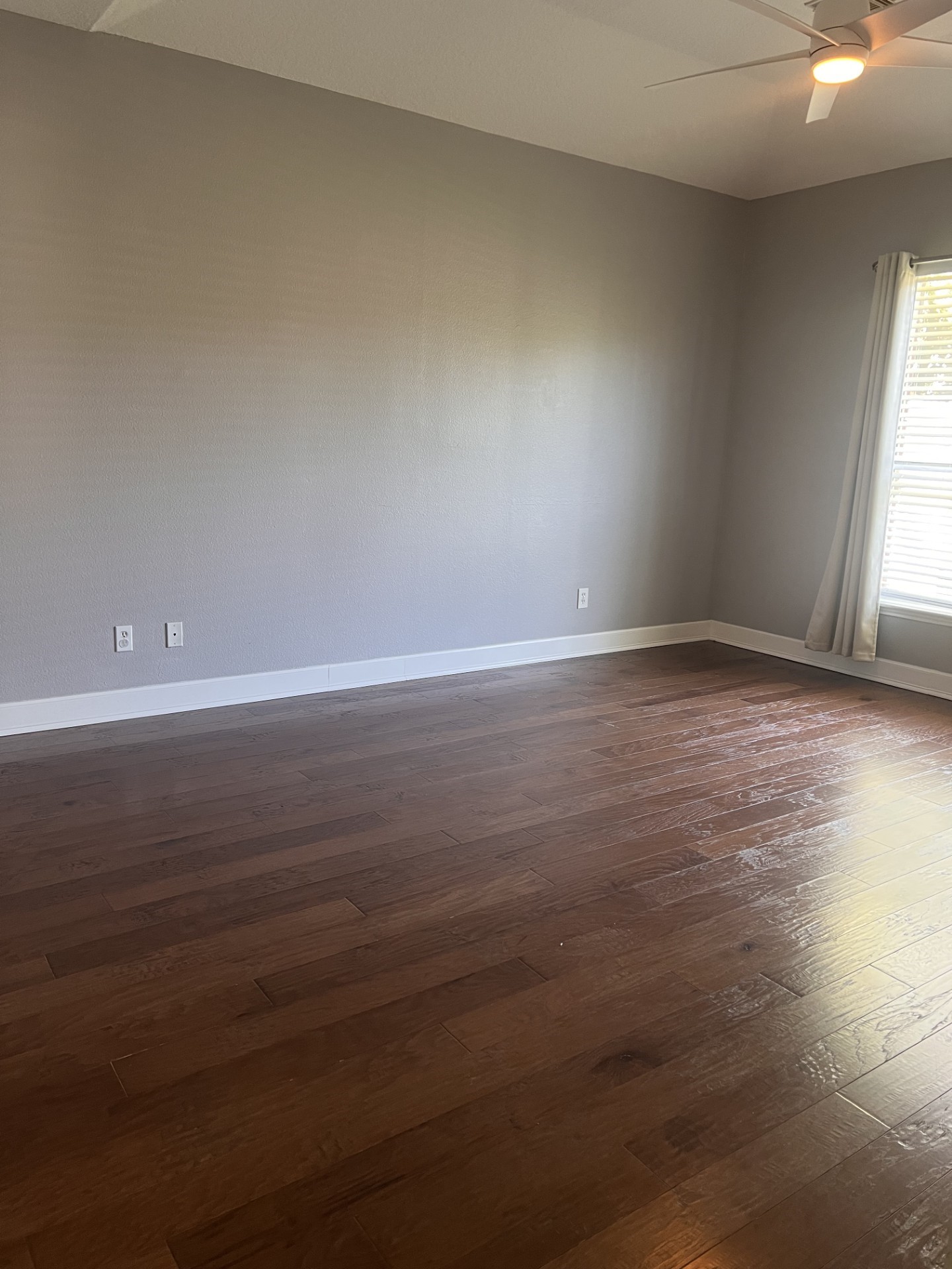 9327 Restover Lane Houston, TX 77064 - Photo 15 of 22 an empty room with wooden floor and windows with curtains