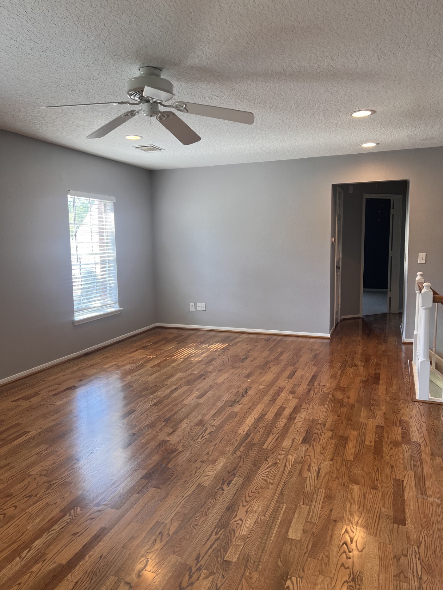 9327 Restover Lane Houston, TX 77064 - Photo 20 of 22 an empty room with wooden floor chandelier fan and windows