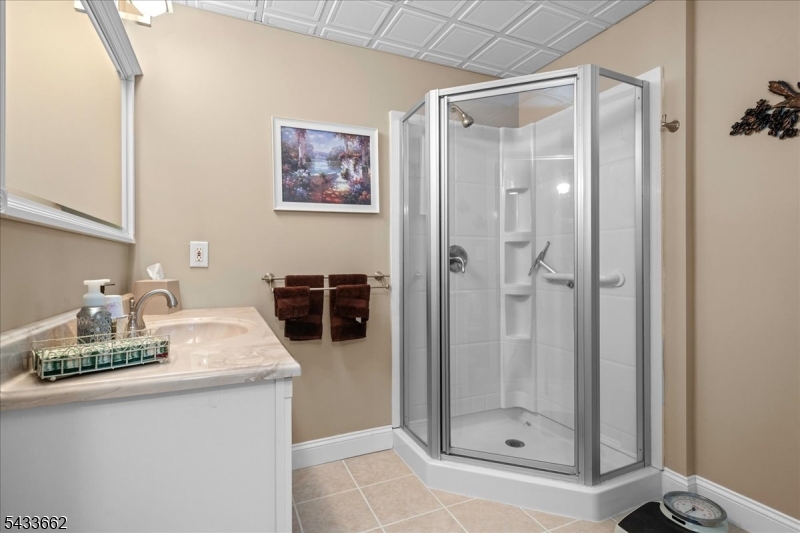 15 Bracken Hill Road Hamburg, NJ 07419 - Photo 35 of 44 a bathroom with a granite countertop sink a mirror a glass door and shower