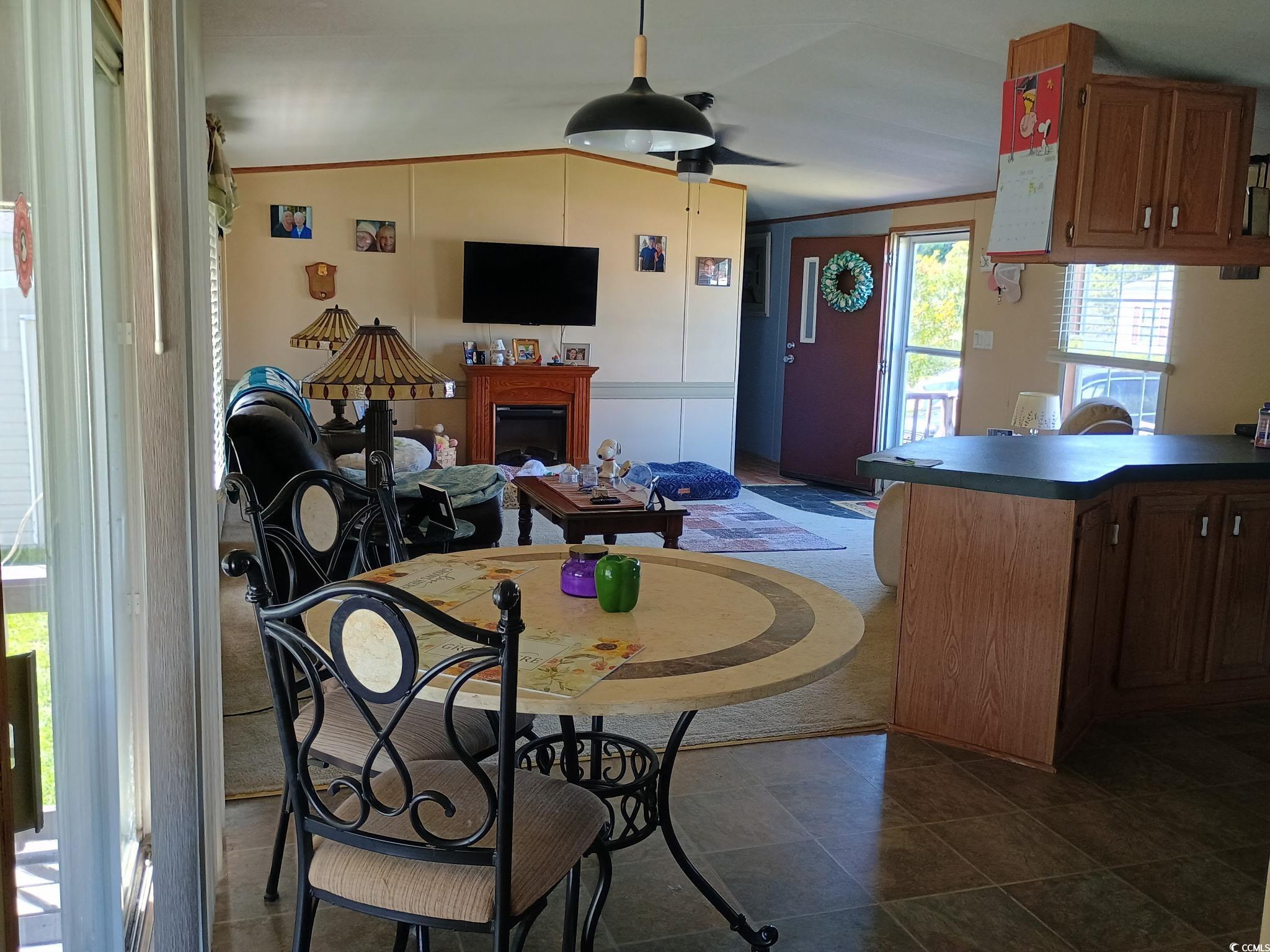 1049 Colonial Lane Conway, SC 29526 - Photo 6 of 27 Dining space with a fireplace, vaulted ceiling, and crown molding