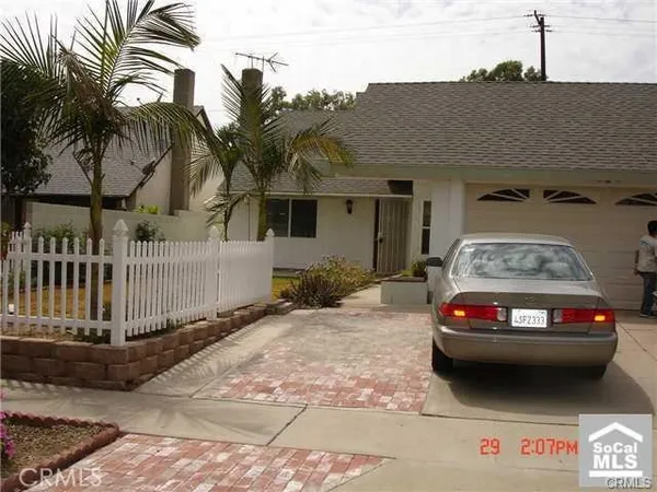 a view of a house with a car parked beside it