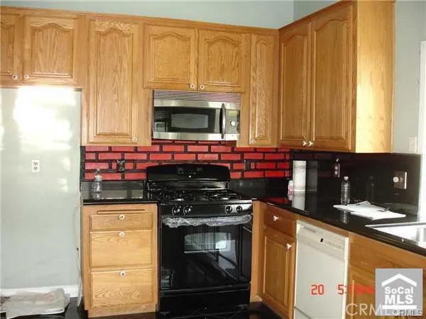 a kitchen with stainless steel appliances a stove a microwave and a window