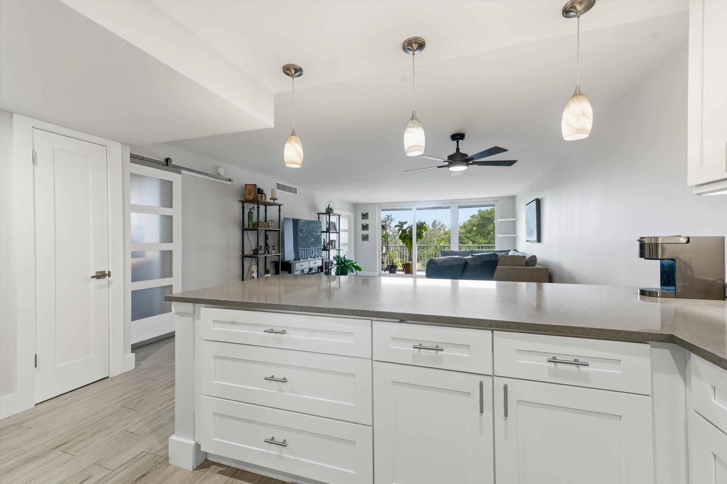2600 South Course Drive, Unit 610 Pompano Beach, FL 33069 - Photo 11 of 33 a kitchen with white cabinets and wooden floor
