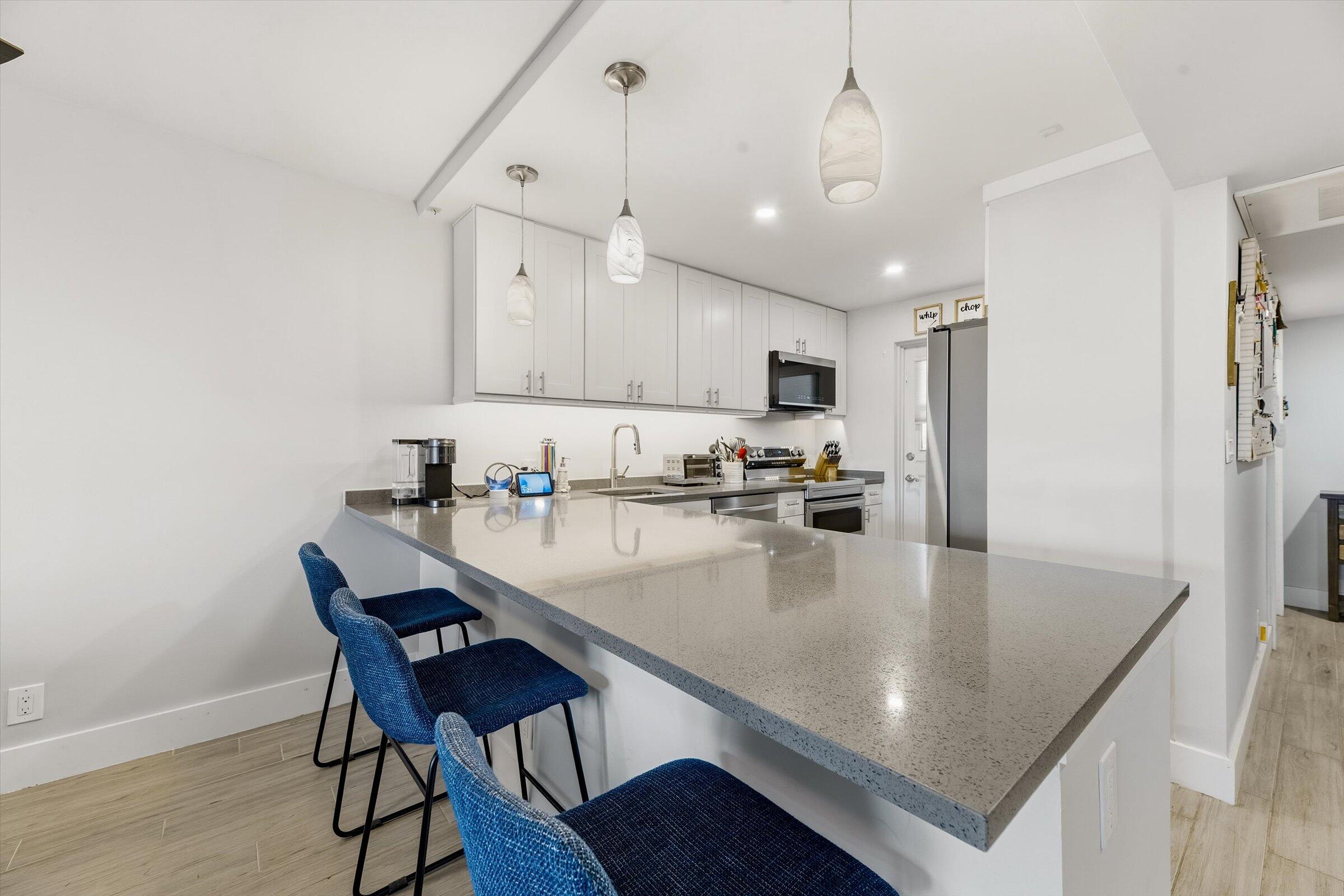 2600 South Course Drive, Unit 610 Pompano Beach, FL 33069 - Photo 8 of 33 a kitchen with stainless steel appliances granite countertop a sink a stove and chairs