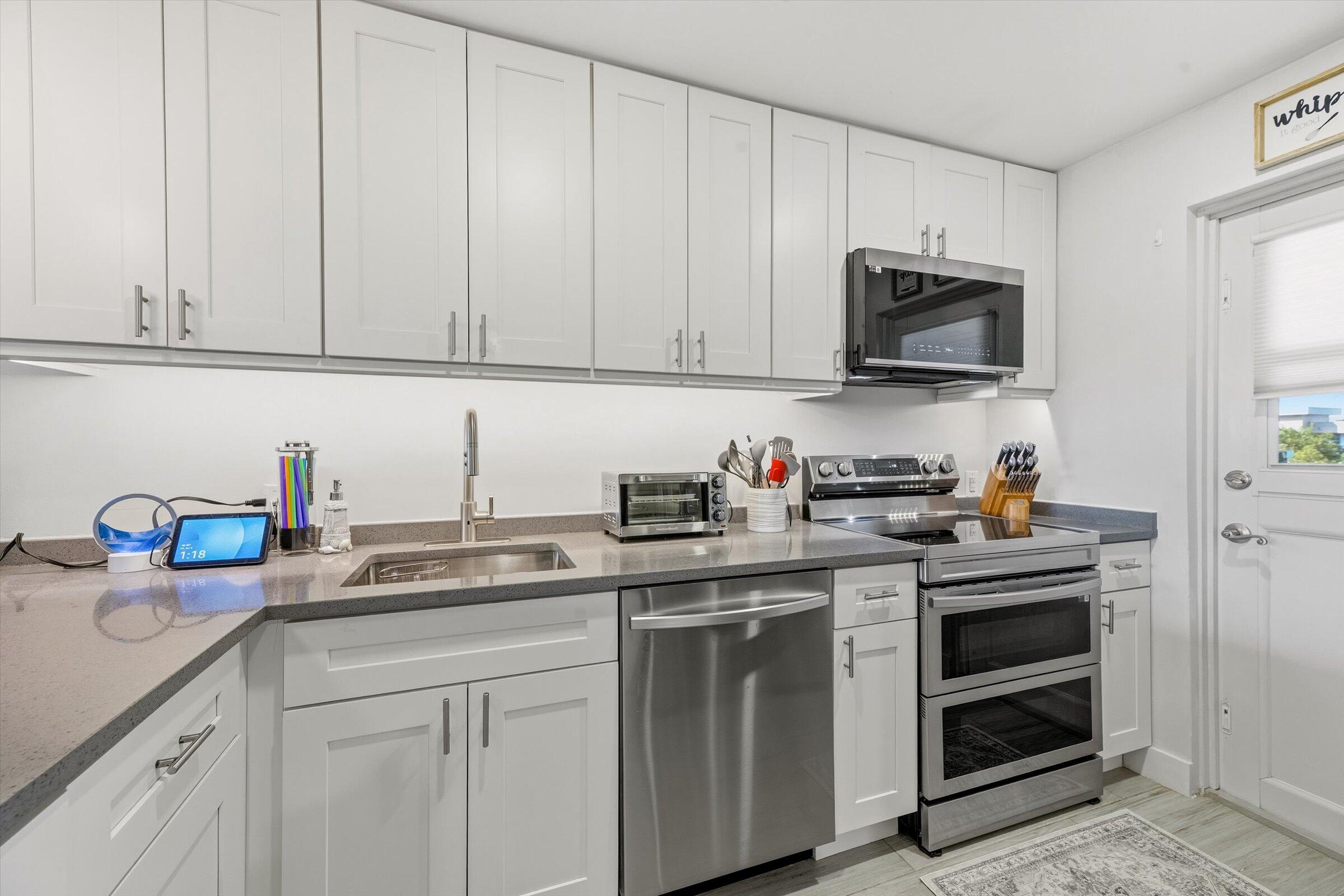 2600 South Course Drive, Unit 610 Pompano Beach, FL 33069 - Photo 9 of 33 a kitchen with stainless steel appliances granite countertop white cabinets a sink and dishwasher
