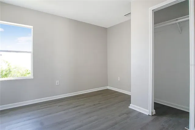 an empty room with wooden floor and closet